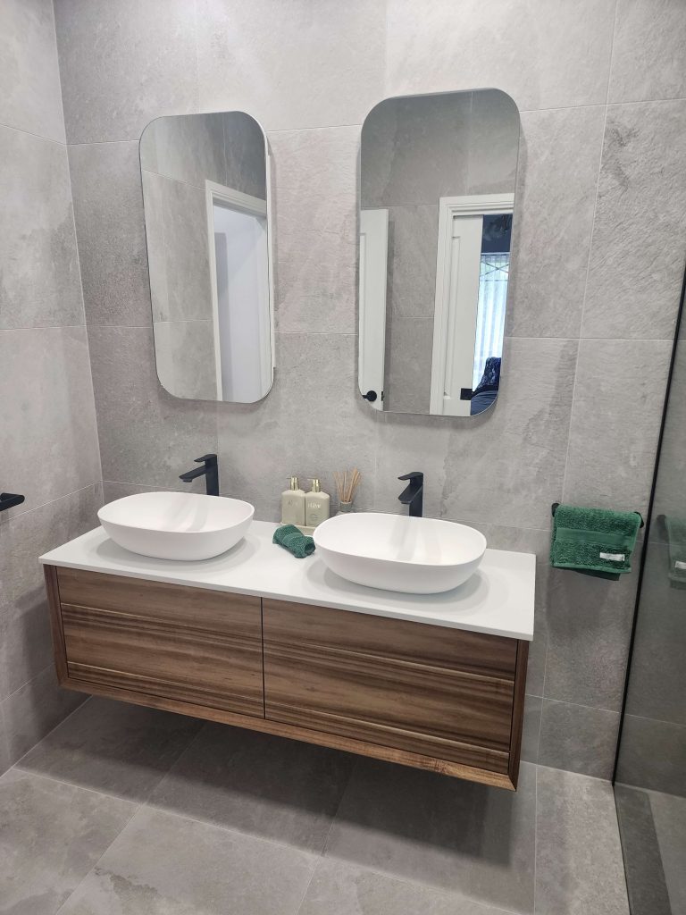 Victor Harbor Bathroom renovation A floating double vanity unit in a Victor Harbor bathroom featuring wood finish, black tapware and double mirrors.